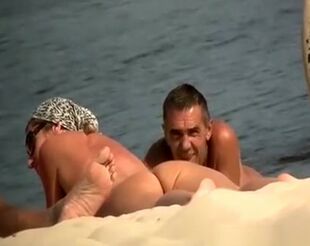 Hidden cam at naturist beach films naked dudes and doll