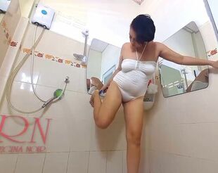 Lovable woman trims her underarms in the shower, lathers her